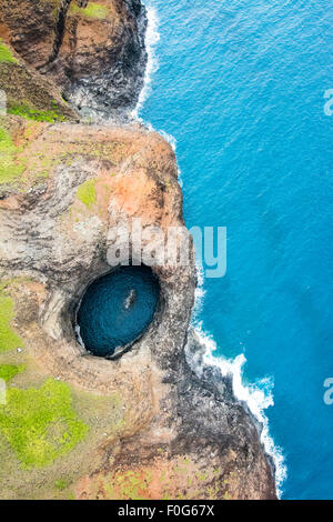 An aerial view of the Na Pali coast's Open Ceiling Cave during a vibrant, sunny day shows the rich colors of the coastline Stock Photo