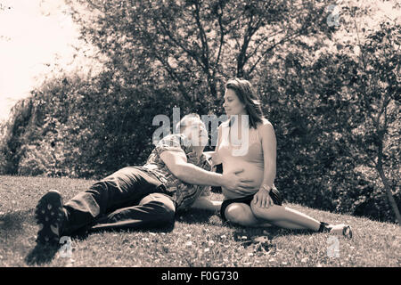 Portrait of happy proud couple expecting baby and relaxing in the nature. Stock Photo