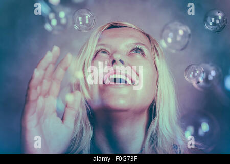 Beautiful smiling blond girl looking up and enjoying fabulous wonderland. Stock Photo