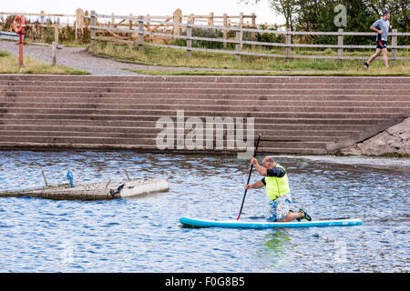 A man Giving paddle boarding lessons to a group of people at Chasewater Country Park lichfield, Staffordshire, UK Stock Photo