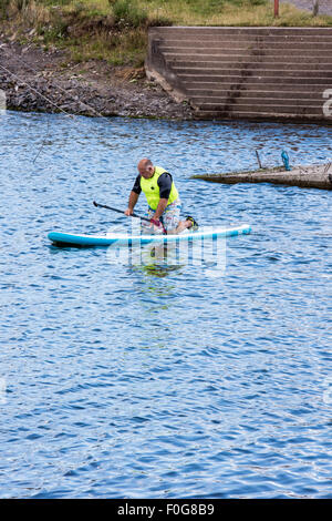 A man Giving paddle boarding lessons to a group of people at Chasewater Country Park lichfield, Staffordshire, UK Stock Photo