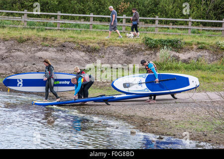 A man Giving paddle boarding lessons to a group of people at Chasewater Country Park lichfield, Staffordshire, UK Stock Photo