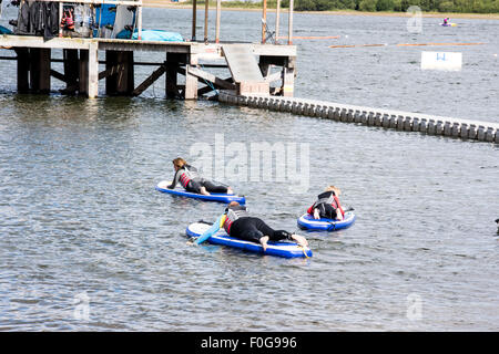 A man Giving paddle boarding lessons to a group of people at Chasewater Country Park lichfield, Staffordshire, UK Stock Photo