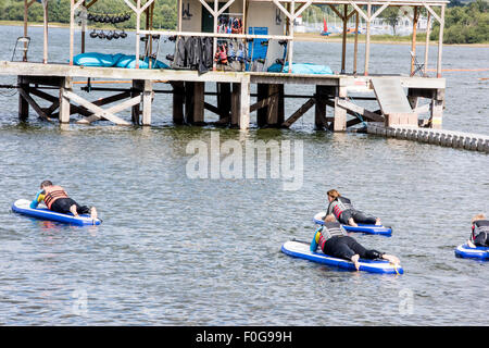 A man Giving paddle boarding lessons to a group of people at Chasewater Country Park lichfield, Staffordshire, UK Stock Photo