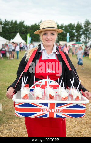 Newchurch, Isle of Wight, UK. 15th Aug, 2015. A girl sells strawberries and cream at the festival, the Island’s biggest summer food fair and entertainment event. The festival celebrates the famous garlic grown on the Island and other local foods, crafts, music and family entertainment. Credit: Julian Eales/Alamy Live News Stock Photo