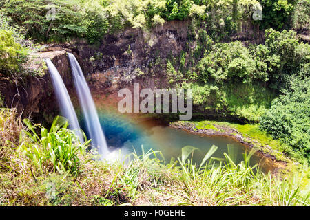 Beautiful Opaekaa Falls in Kauai Hawaii forms a rainbow when the sun angle contacts mist at the right time of day.W Stock Photo