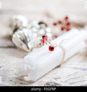 white candles tied with twine, red berries and silver baubles Stock Photo
