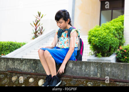 Sad  girl sitting and  thinking in the school Stock Photo