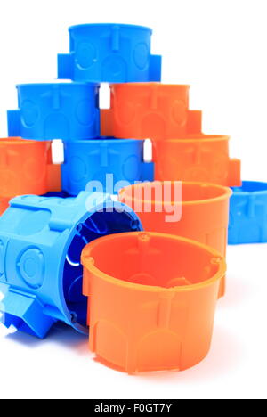 Blue and orange plastic electrical boxes on white background, components for use in electrical installations, Stock Photo