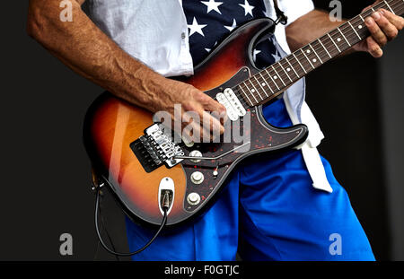 Adult Male playing on stage an electric guitar Stock Photo