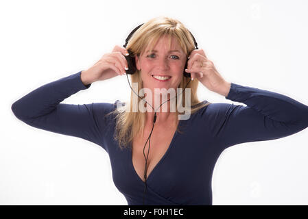 Attractive woman holding headphones to her ears Listening to music Stock Photo