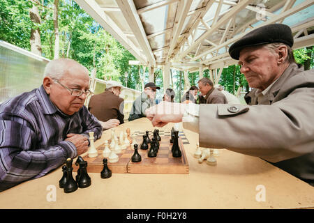 BELARUS, GOMEL - MAY 9, 2014: Active retired people, old friends and free time, senior men having fun and playing chess at city Stock Photo