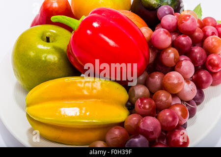 Various kinds of fruits in plate isolated on white background. Stock Photo