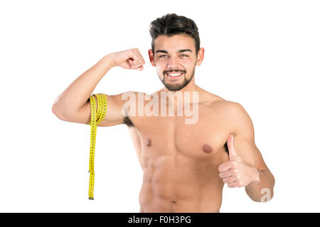 Handsome and fit young man with measuring tape isolated in white Stock Photo