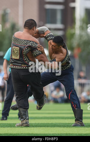 (150816) -- ORDOS, Aug 16, 2015 (Xinhua) -- Two Mongolian wrestlers compete in men's individual event of the Mongolian wrestling, or 'Boke' in Chinese, during the 10th National Traditional Games of Ethnic Minorities of China in Ordos, north China's Inner Mongolia Autonomous Region, Aug. 16, 2015. Boke, with the meaning of 'strong and healthy' in the Mongolian language, is a historic sport practiced by the Mongolian people and is popular among normadic people in northern China. The wrestlers, usually armored with leather jackets dotted by silver buttons, hold each others' arms and try every mea Stock Photo