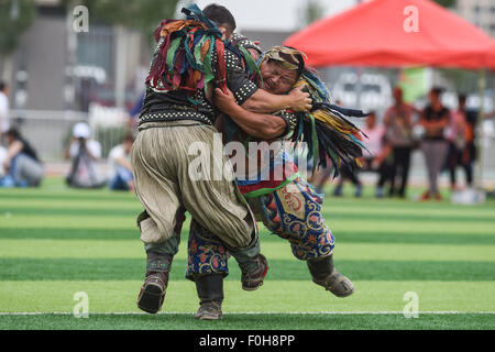 (150816) -- ORDOS, Aug 16, 2015 (Xinhua) -- Two Mongolian wrestlers compete in men's individual event of the Mongolian wrestling, or 'Boke' in Chinese, during the 10th National Traditional Games of Ethnic Minorities of China in Ordos, north China's Inner Mongolia Autonomous Region, Aug. 16, 2015. Boke, with the meaning of 'strong and healthy' in the Mongolian language, is a historic sport practiced by the Mongolian people and is popular among normadic people in northern China. The wrestlers, usually armored with leather jackets dotted by silver buttons, hold each others' arms and try every mea Stock Photo