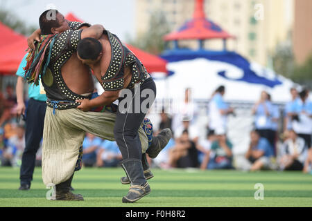 (150816) -- ORDOS, Aug 16, 2015 (Xinhua) -- Two Mongolian wrestlers compete in men's individual event of the Mongolian wrestling, or 'Boke' in Chinese, during the 10th National Traditional Games of Ethnic Minorities of China in Ordos, north China's Inner Mongolia Autonomous Region, Aug. 16, 2015. Boke, with the meaning of 'strong and healthy' in the Mongolian language, is a historic sport practiced by the Mongolian people and is popular among normadic people in northern China. The wrestlers, usually armored with leather jackets dotted by silver buttons, hold each others' arms and try every mea Stock Photo