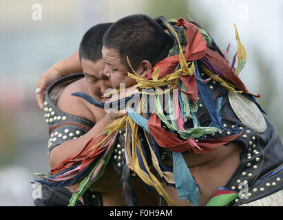 (150816) -- ORDOS, Aug 16, 2015 (Xinhua) -- A Mongolian wrestler wearing jangga, an honor symbol for Mongolian wrestlers, competes with another wrestler in men's individual event of the Mongolian wrestling, or 'Boke' in Chinese, during the 10th National Traditional Games of Ethnic Minorities of China in Ordos, north China's Inner Mongolia Autonomous Region, Aug. 16, 2015. Boke, with the meaning of 'strong and healthy' in the Mongolian language, is a historic sport practiced by the Mongolian people and is popular among normadic people in northern China. (Xinhua/Wu Wei) Stock Photo