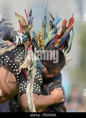 (150816) -- ORDOS, Aug 16, 2015 (Xinhua) -- A Mongolian wrestler wearing jangga, an honor symbol for Mongolian wrestlers, competes with another wrestler in men's individual event of the Mongolian wrestling, or 'Boke' in Chinese, during the 10th National Traditional Games of Ethnic Minorities of China in Ordos, north China's Inner Mongolia Autonomous Region, Aug. 16, 2015. Boke, with the meaning of 'strong and healthy' in the Mongolian language, is a historic sport practiced by the Mongolian people and is popular among normadic people in northern China. (Xinhua/Wu Wei) Stock Photo