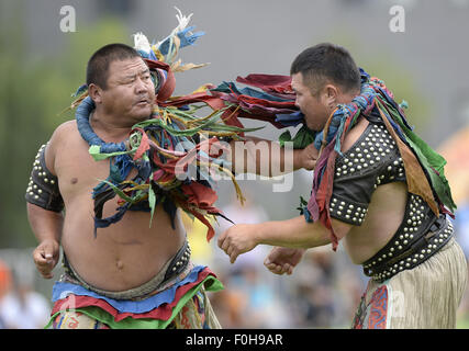 (150816) -- ORDOS, Aug 16, 2015 (Xinhua) -- Two Mongolian wrestlers wearing jangga, an honor symbol for Mongolian wrestlers, compete with each other in men's individual event of the Mongolian wrestling, or 'Boke' in Chinese, during the 10th National Traditional Games of Ethnic Minorities of China in Ordos, north China's Inner Mongolia Autonomous Region, Aug. 16, 2015. Boke, with the meaning of 'strong and healthy' in the Mongolian language, is a historic sport practiced by the Mongolian people and is popular among normadic people in northern China. (Xinhua/Wu Wei) Stock Photo