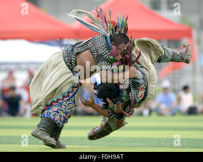 (150816) -- ORDOS, Aug 16, 2015 (Xinhua) -- Two Mongolian wrestlers wearing jangga, an honor symbol for Mongolian wrestlers, compete with each other in men's individual event of the Mongolian wrestling, or 'Boke' in Chinese, during the 10th National Traditional Games of Ethnic Minorities of China in Ordos, north China's Inner Mongolia Autonomous Region, Aug. 16, 2015. Boke, with the meaning of 'strong and healthy' in the Mongolian language, is a historic sport practiced by the Mongolian people and is popular among normadic people in northern China. (Xinhua/Wu Wei) Stock Photo