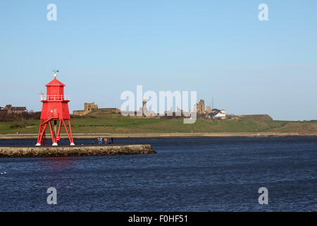 Tynemouth Priory and the Collingwood Memorial at Tynemouth, England. Herd Groyne lighthouse stands by the River Tyne. Stock Photo