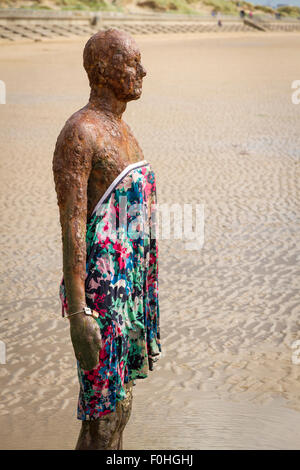 Antony Gormleys Another Place Sculpture on Crosby Beach wearing a dress Stock Photo