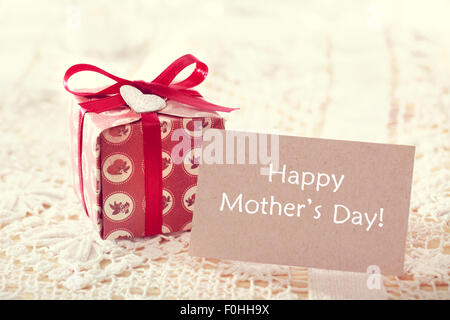 Happy mothers day message written on a card with a hand crafted present box Stock Photo