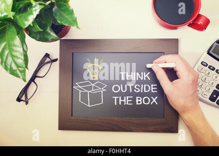 Man drawing Think outside the box on chalkboard Stock Photo