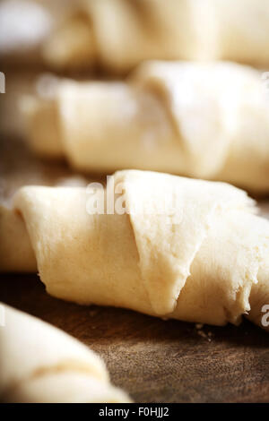 Croissants dough freshly prepared for baking on wooden board Stock Photo