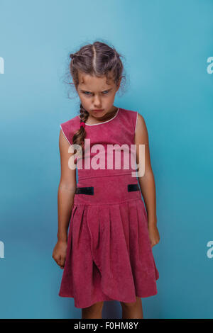 Girl European appearance decade  angry frowns on blue background Stock Photo
