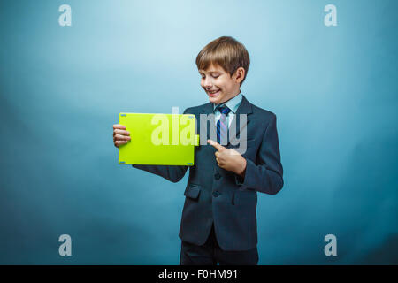 Teen boy businessman in a suit points to the plate on the backgr Stock Photo