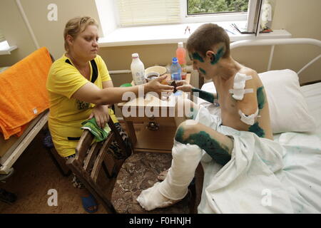 Donetsk. 15th Aug, 2015. Photo taken on Aug. 15, 2015 shows a 12-year-old boy Andrey(R) and his mother Elena at a traumatological hospital in Donetsk, Ukraine. A week ago Andrey and two boys played with an unexploded grenade, which exploded at those moment. Three boys were injured by the explosion. Andrey had one-week rehabilitation period in hospital and now he was in stable condition. © Alexander Ermochenko/Xinhua/Alamy Live News Stock Photo