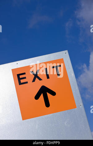 Orange exit sign against the blue sky Stock Photo