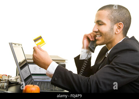 Business man buying online with credit card while talking on the phone Stock Photo
