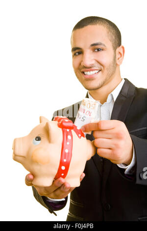 Happy business man putting Euro banknotes in piggy bank Stock Photo