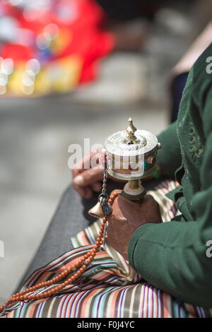 Unidentified old woman praying with prayer roll at the Palkhor Monastery in Lhasa. Tibet 2013 Stock Photo