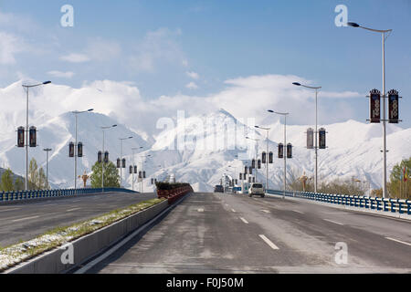 Leaving Lhasa on an empty Friendship Highway with a stunning view of the Himalayan mountain chain in the background. Tibet, Chin Stock Photo