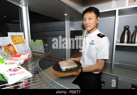 (150817) -- HARBIN, Aug. 17, 2015 (Xinhua) -- A steward prepares lunch for passengers on the high-speed train D7989, northeast China's Heilongjiang Province, Aug. 17, 2015. China's northernmost high-speed railway between two cities of Harbin and Qiqihar in Heilongjiang started operation on Monday. With a designated speed of 250 kilometers per hour and eight stops, the trip from Harbin to Qiqihar was reduced from three hours to 85 minutes. The trains have been modified to adapt to temperatures as low as minus 40 degrees Celsius and resist adverse weather, such as strong winds, heavy rain, snow  Stock Photo