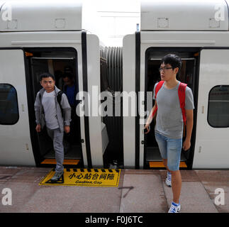 (150817) -- HARBIN, Aug. 17, 2015 (Xinhua) -- Passengers get off the train at the Daqing West Railway Station in Daqing, northeast China's Heilongjiang Province, Aug. 17, 2015. China's northernmost high-speed railway between two cities of Harbin and Qiqihar in Heilongjiang started operation on Monday. With a designated speed of 250 kilometers per hour and eight stops, the trip from Harbin to Qiqihar was reduced from three hours to 85 minutes. The trains have been modified to adapt to temperatures as low as minus 40 degrees Celsius and resist adverse weather, such as strong winds, heavy rain, s Stock Photo