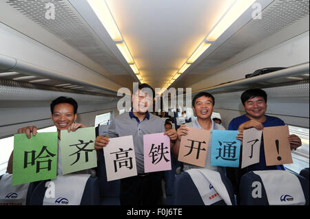 (150817) -- HARBIN, Aug. 17, 2015 (Xinhua) -- Passengers celebrate on the high-speed train D7989, northeast China's Heilongjiang Province, Aug. 17, 2015. China's northernmost high-speed railway between two cities of Harbin and Qiqihar in Heilongjiang started operation on Monday. With a designated speed of 250 kilometers per hour and eight stops, the trip from Harbin to Qiqihar was reduced from three hours to 85 minutes. The trains have been modified to adapt to temperatures as low as minus 40 degrees Celsius and resist adverse weather, such as strong winds, heavy rain, snow and fog. (Xinhua/Wa Stock Photo