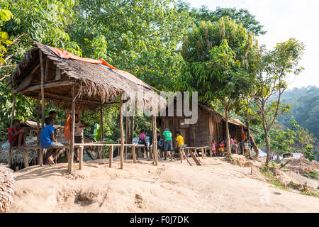 People sitting in front of wooden huts, Orang Asil tribe, aboriginal, indigenous people, Taman Negara National Park, Malaysia Stock Photo