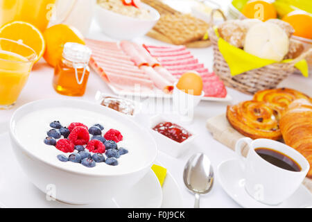 A large buffet-style continental breakfast on a brightly lit table. Stock Photo