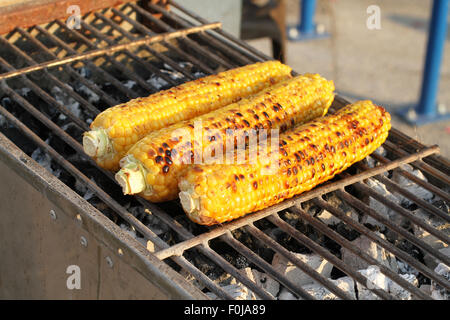 Roasted corn-cobs on brazier grid at the street. Closeup