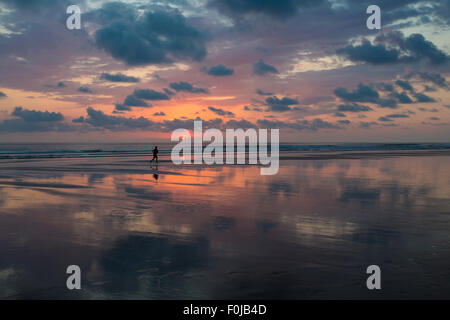 Sunset view at the beach of Matapalo with silhouette of man making his jogging, Costa Rica. Stock Photo