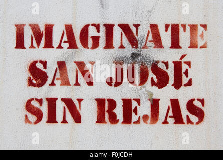 Words Imagine San Jose without gates graffiti on a white wall in the street of Costa Rica Stock Photo