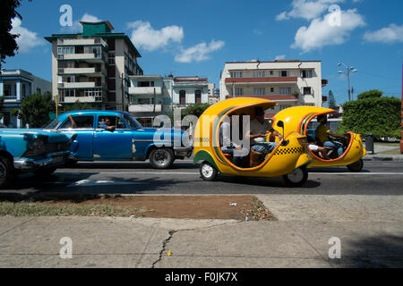 Coco taxis  and classic 1950s cars on the streets of Havana, Cuba Stock Photo