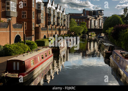 Barges moored along Birmingham's Old Line Canal in evening summer sunlight Stock Photo