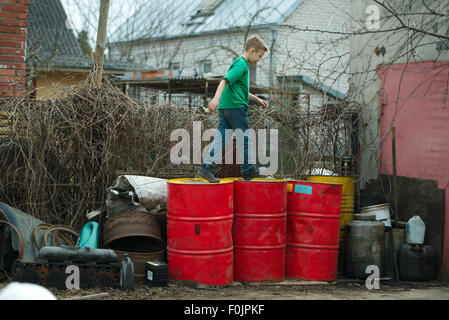 boy walks on the barrels from oil Stock Photo