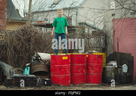 boy walks on the barrels from oil Stock Photo